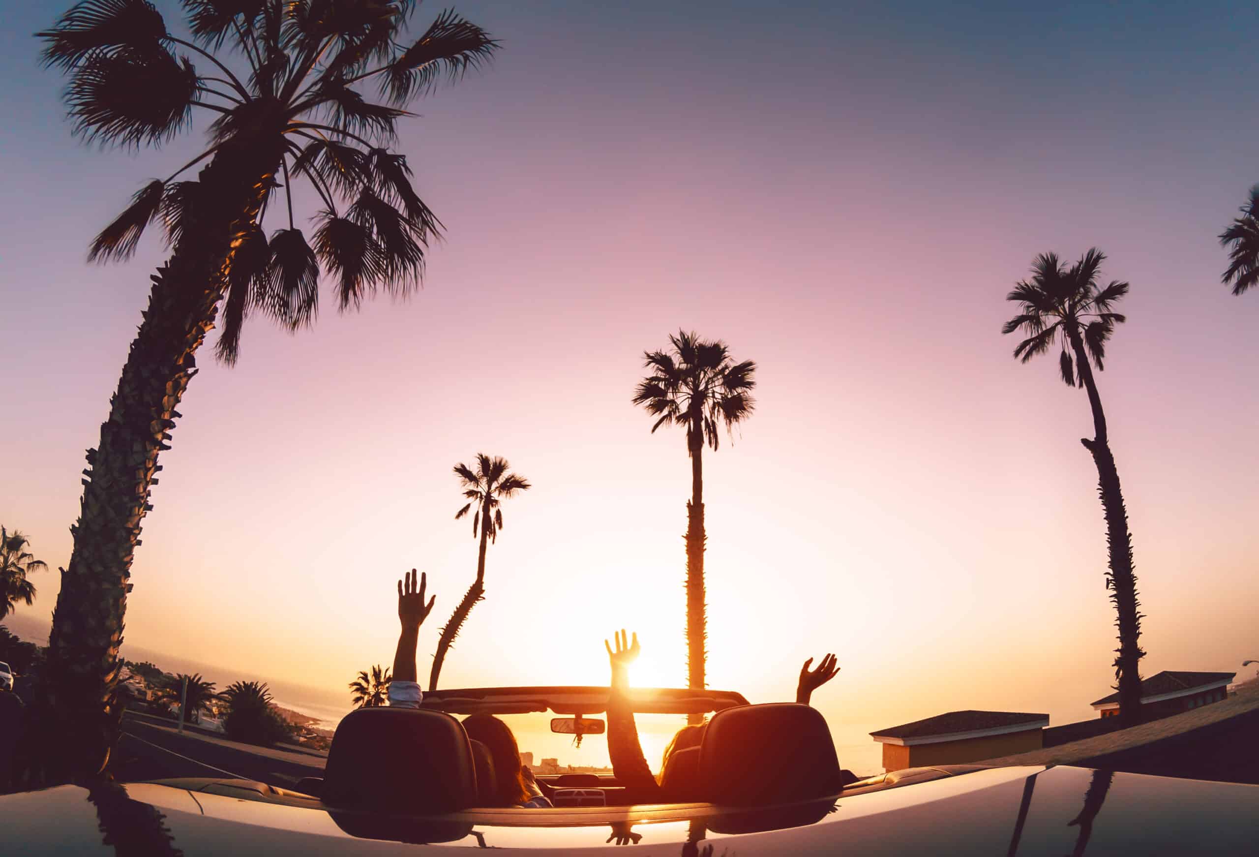 couple in convertible at sunset